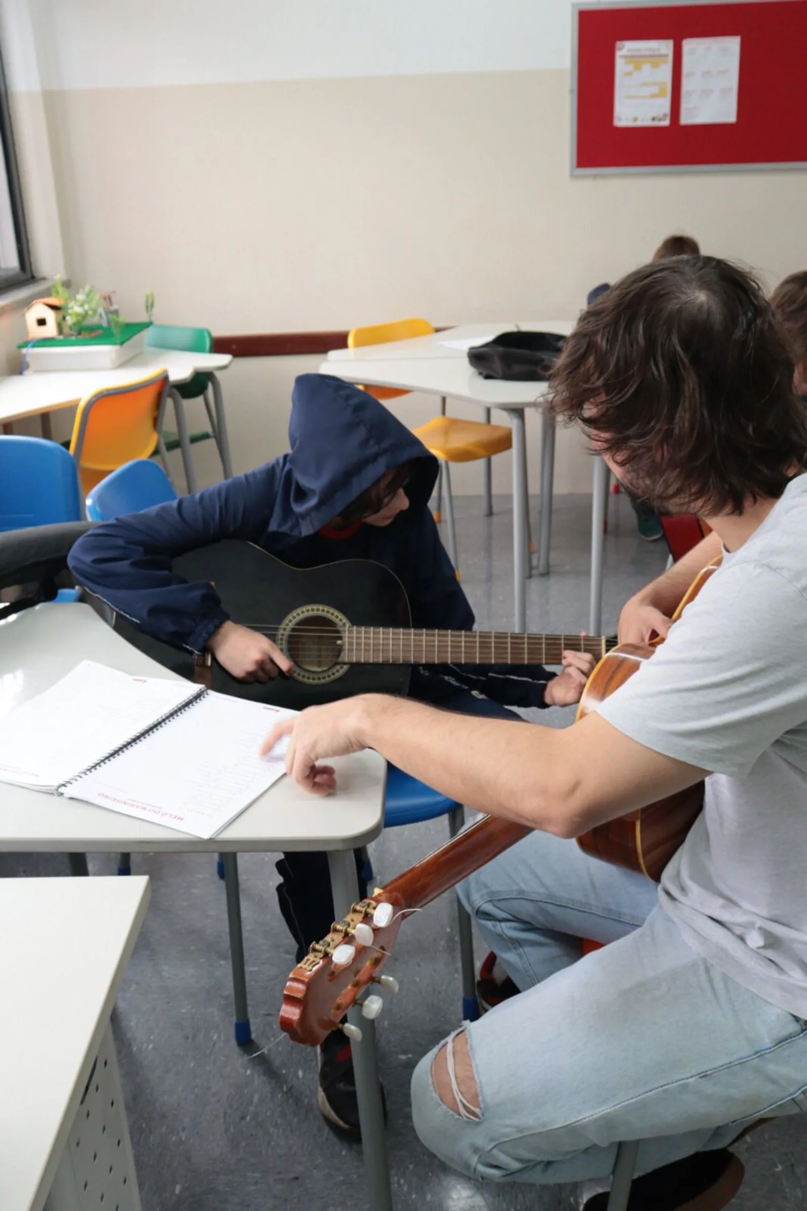 Professor acompanhando de perto um aprendiz durante a aula